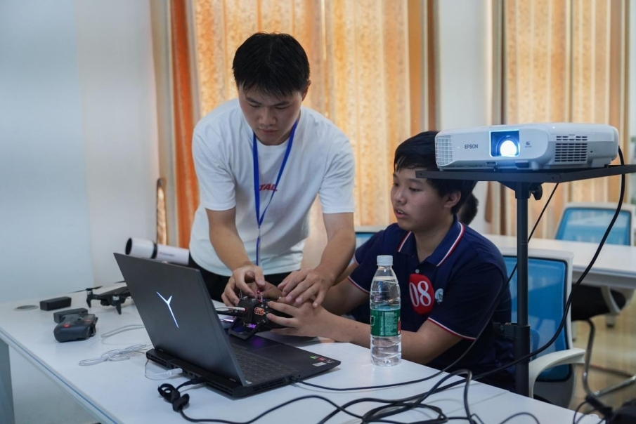 WilliamHill中文官方网站信息工程学院学生正在指导研学团成员操控无人机。